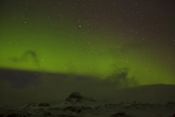 Nordlichter mit verschneiten Bergen im Vordergrund — Stockfoto
