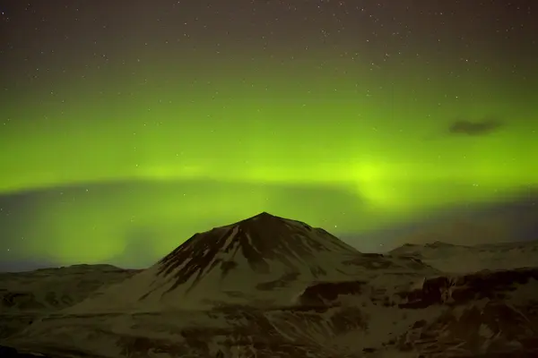 Luces boreales con montañas nevadas en primer plano —  Fotos de Stock