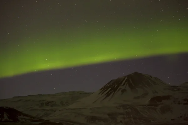 Luces boreales con montañas nevadas en primer plano —  Fotos de Stock