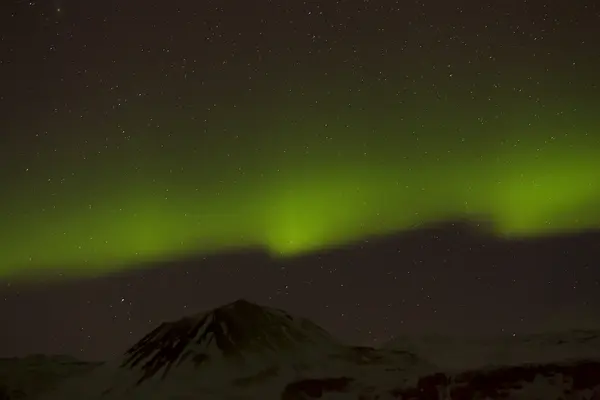 Northern lights with snowy mountains in the foreground — Stock Photo, Image