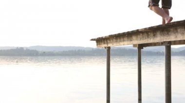 Genç adam dock suya atlar.