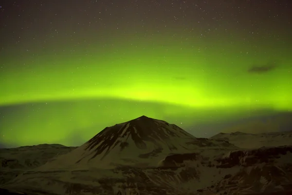 Luces boreales con montañas nevadas en primer plano —  Fotos de Stock