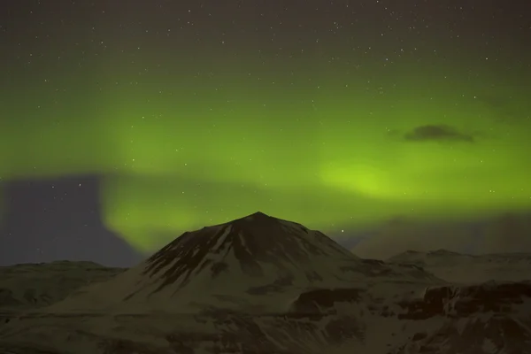 Северное сияние с заснеженными горами на переднем плане — стоковое фото