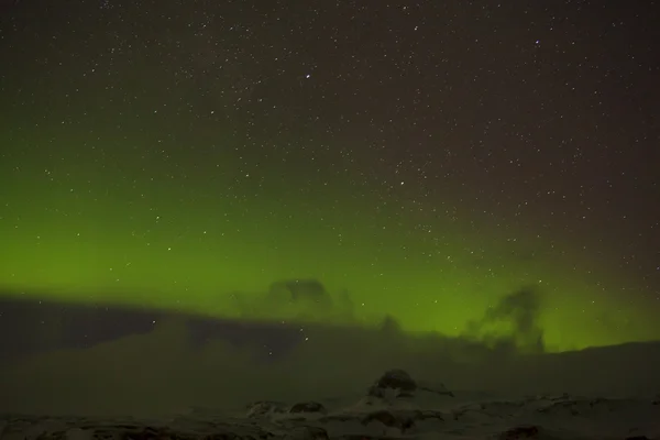 Northern lights met besneeuwde bergen op de voorgrond — Stockfoto