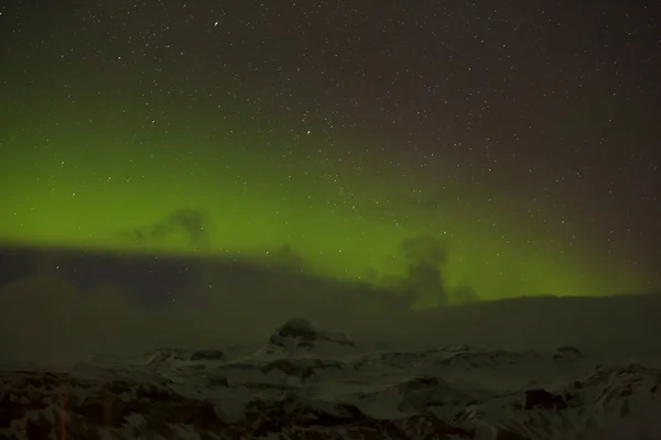 Aurores boréales avec des montagnes enneigées au premier plan — Photo