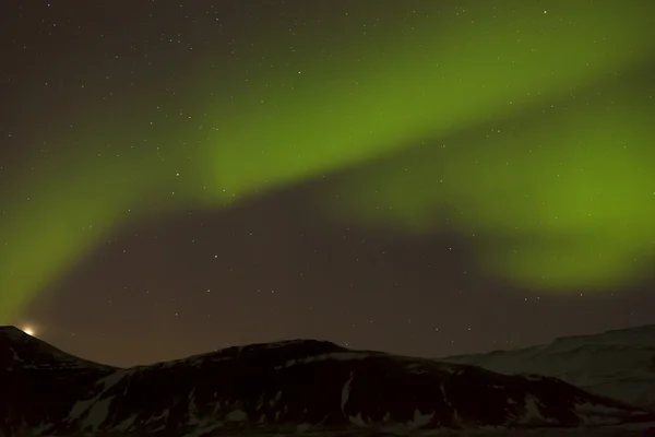 Luces boreales con montañas nevadas en primer plano —  Fotos de Stock