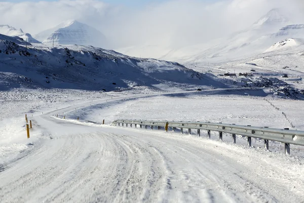 Estrada nevada e gelada com montanhas vulcânicas no inverno — Fotografia de Stock