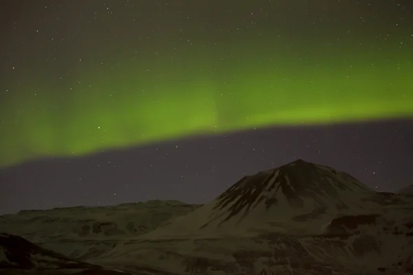 Nordlichter mit verschneiten Bergen im Vordergrund — Stockfoto