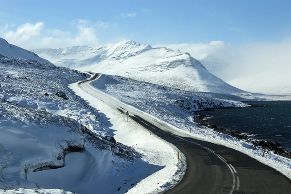 Estrada nevada e gelada com montanhas vulcânicas no inverno — Fotografia de Stock