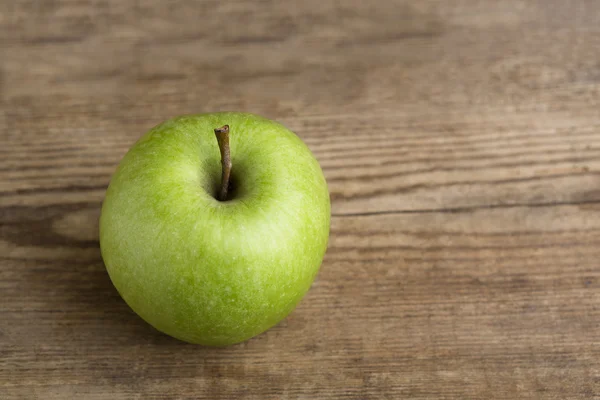 Green apple on wooden background — Stock Photo, Image