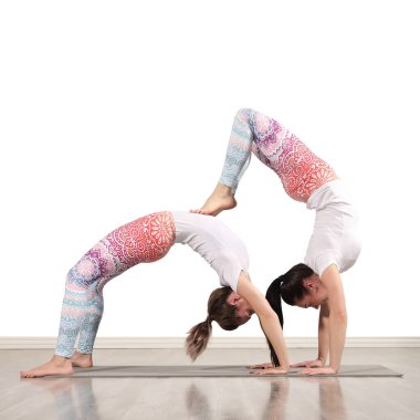 İki sıska kadın içeride yoga yapıyor.