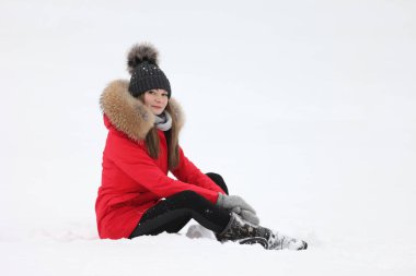 Kışın kar altında kırmızı ceketli genç bir kadın