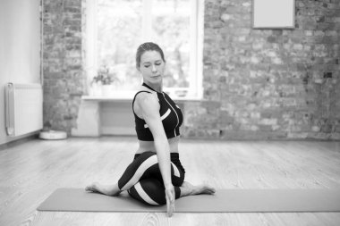 Genç kadın yoga öğretmeni stüdyoda çalışıyor.