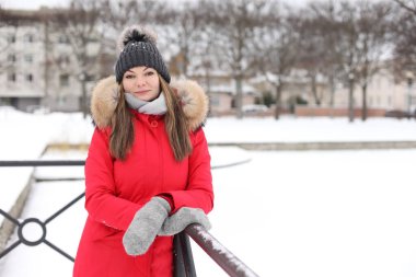 Kışın kar altında kırmızı ceketli genç bir kadın