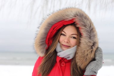 Kışın kar altında kırmızı ceketli genç bir kadın