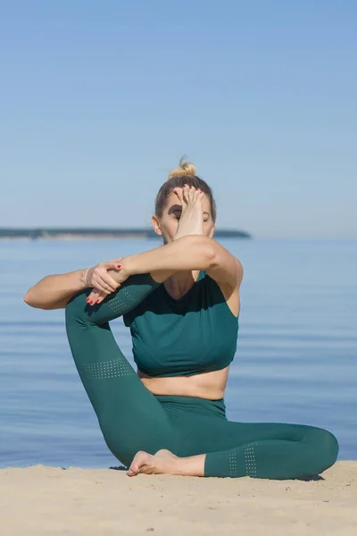 Woman doing yoga at the sea. Beauty fitness woman