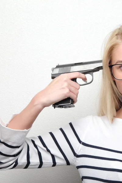 Eine Pistole Auf Einen Frauentempel Vor Grauem Hintergrund — Stockfoto