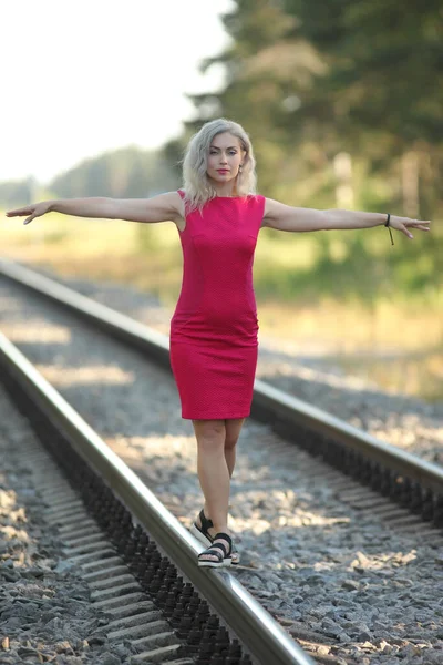 鉄道の赤いドレスを着た若い女性が — ストック写真