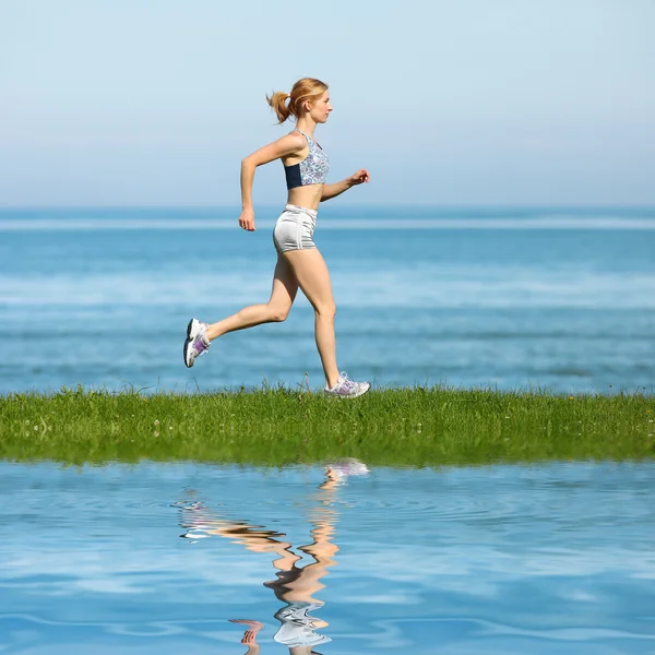 Jeune femme jogging sur la plage — Photo