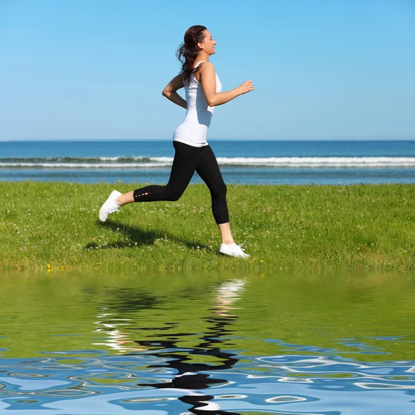 Mujer joven corriendo en la playa — Foto de Stock