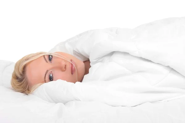 Mujer joven en la cama aislada — Foto de Stock