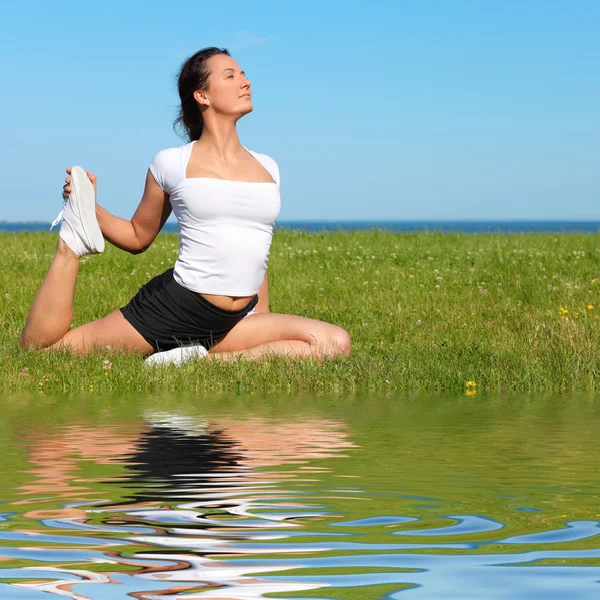 Vacker yoga kvinna utövar yoga av havet — Stockfoto