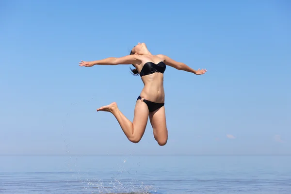 年轻漂亮的女孩，在海面上跳跃 — 图库照片