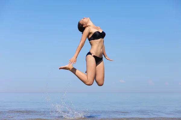 Mooi meisje springen op zee — Stockfoto