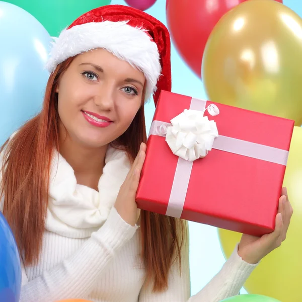 Christmas.smiling mulher em santa chapéu auxiliar com caixas de presente — Fotografia de Stock