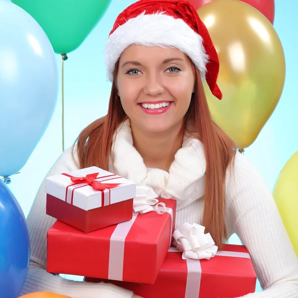 Christmas.Smiling vrouw in helper kerstmuts met een geschenkdozen — Stockfoto
