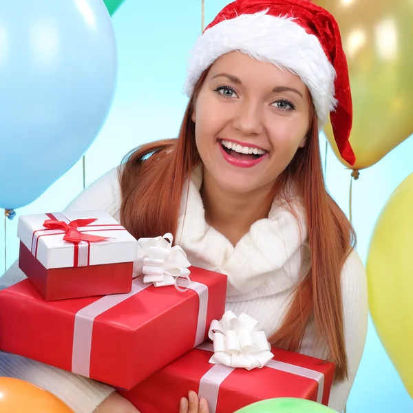 Christmas.Smiling vrouw in helper kerstmuts met een geschenkdozen — Stockfoto