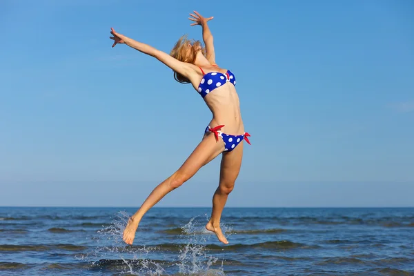 Wesoła dziewczyna, skoki na morzu — Zdjęcie stockowe