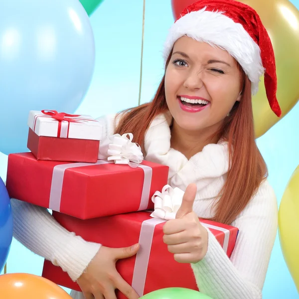 Christmas.Smiling vrouw in helper kerstmuts met een geschenkdozen — Stockfoto