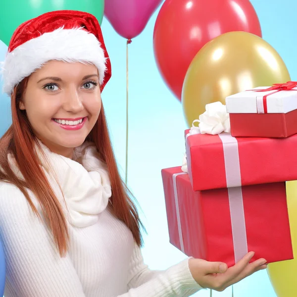 Christmas.Smiling vrouw in helper kerstmuts met een geschenkdozen — Stockfoto