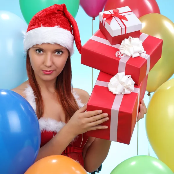 Christmas.smiling γυναίκα στο santa καπέλο βοηθός με κουτιά δώρων — Φωτογραφία Αρχείου