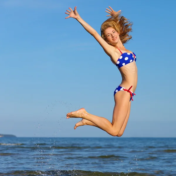 Wesoła dziewczyna, skoki na morzu — Zdjęcie stockowe