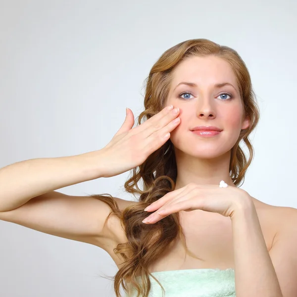 Schönheit Gesicht der jungen Frau mit kosmetischer Creme — Stockfoto