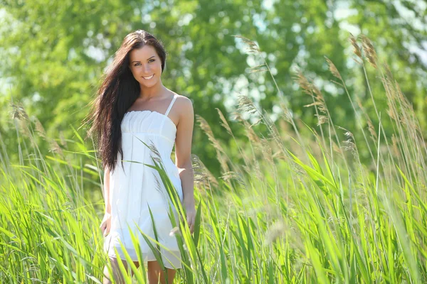 Sexy jovem mulher em um vestido branco na grama — Fotografia de Stock