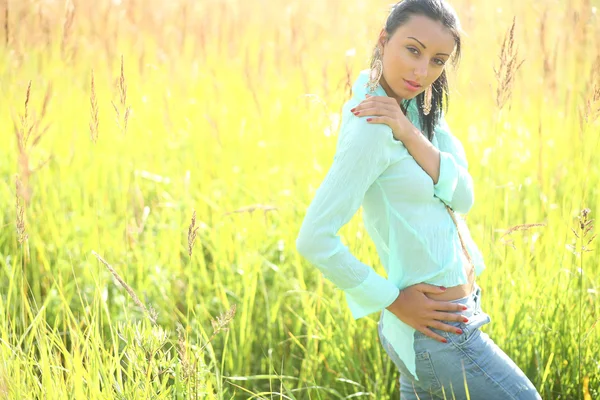 Schöne junge Frau posiert auf dem Gras — Stockfoto