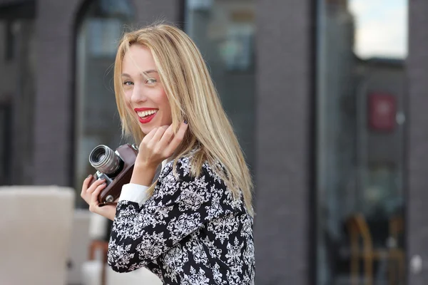 Buiten foto blond meisje met een camera — Stockfoto