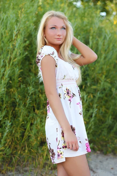 Sexy jonge vrouw in jurk in het gras — Stockfoto