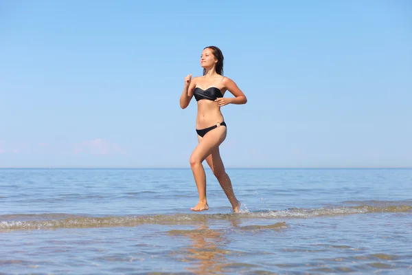 Žena běžící ve vodě — Stock fotografie