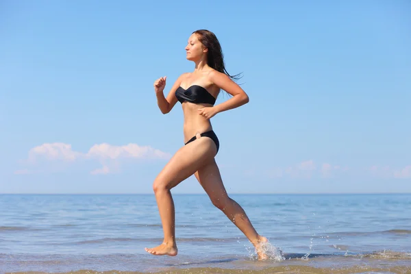 Žena běžící ve vodě — Stock fotografie