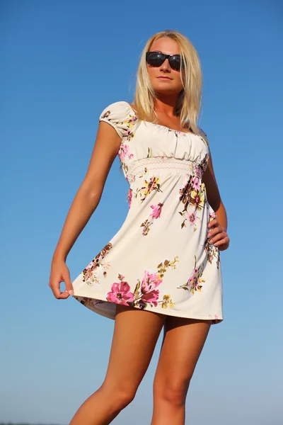 Chica en vestido y gafas de sol en el fondo del cielo —  Fotos de Stock