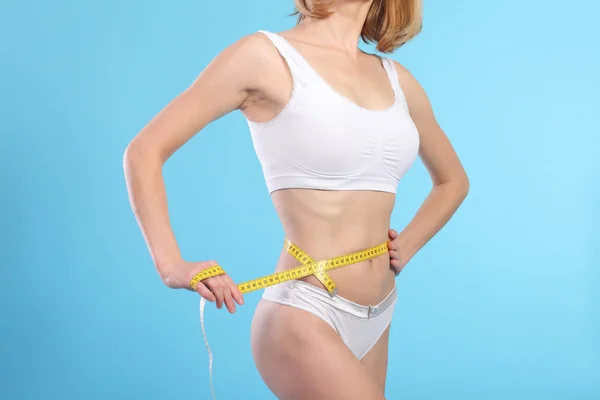 Mulher com fita métrica sobre branco — Fotografia de Stock