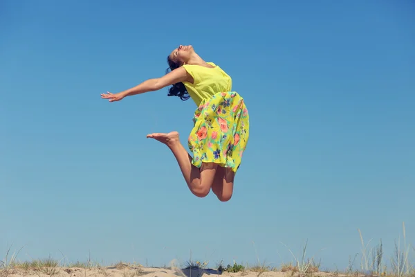 Ung kvinna i sommar klänning hoppning — Stockfoto