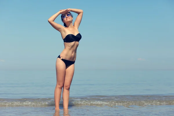 Sexy meisje in een zwembroek op de zee — Stockfoto