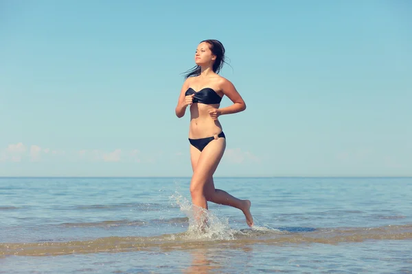 Женщина, бегущая в воде — стоковое фото