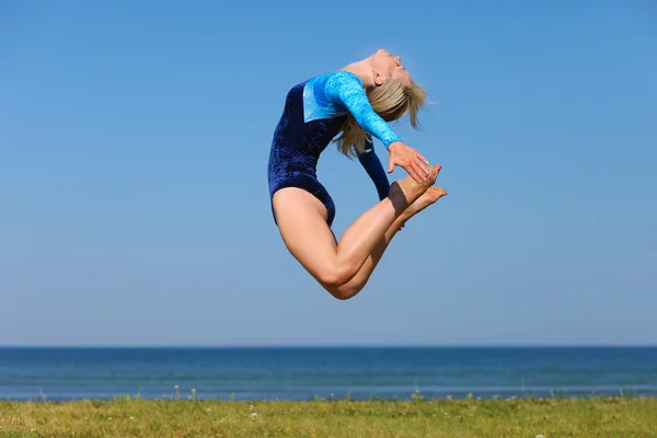 Deniz kıyısı üzerinde genç jimnastikçi — Stok fotoğraf