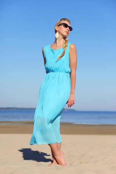 Девушка в синем платье и солнечных очках на фоне неба — стоковое фото